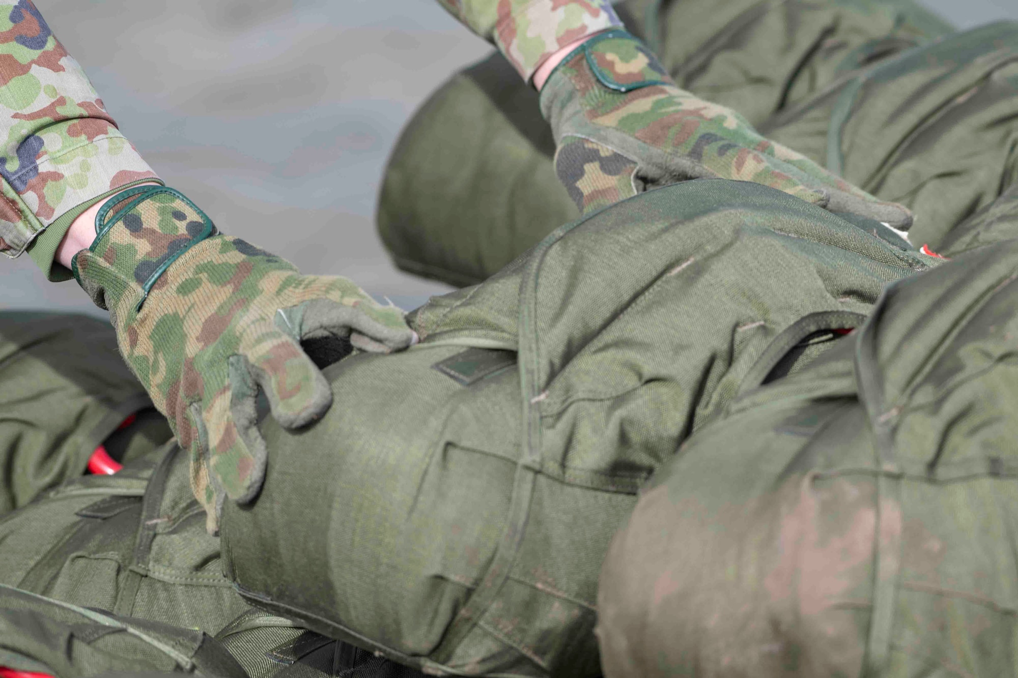 A Japan Ground Self-Defense Force paratrooper assigned to the 1st Airborne Brigade places his gear at the meeting point after completing an airborne jump from a U.S. Air Force C-130J Super Hercules assigned to the 36th Airlift Squadron at Combined Arms Training Center Camp Fuji, Japan, during Airborne 22, Jan. 25, 2022.