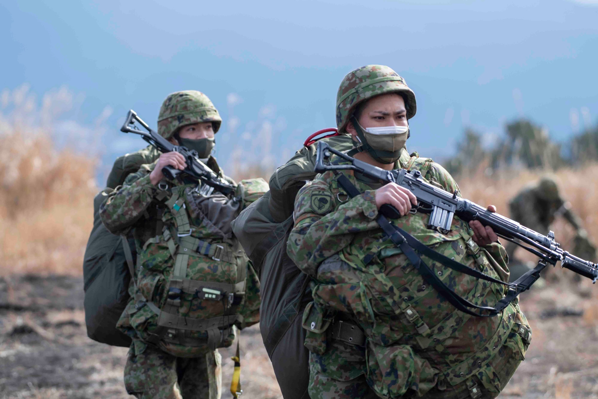 Japan Ground Self-Defense Force paratroopers assigned to the 1st Airborne Brigade proceed to a meeting point after completing an airborne jump from a U.S. Air Force C-130J Super Hercules assigned to the 36th Airlift Squadron at Combined Arms Training Center Camp Fuji, Japan, during Airborne 22, Jan. 25, 2022.