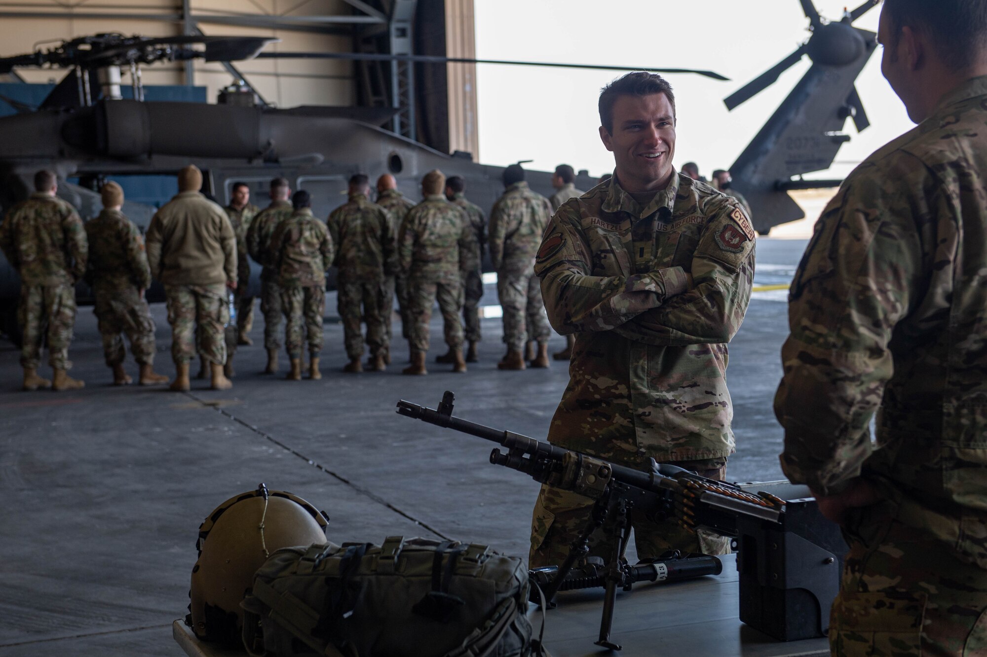 Airman discusses UH-60 Blackhawk crew chief equipment with Soldier