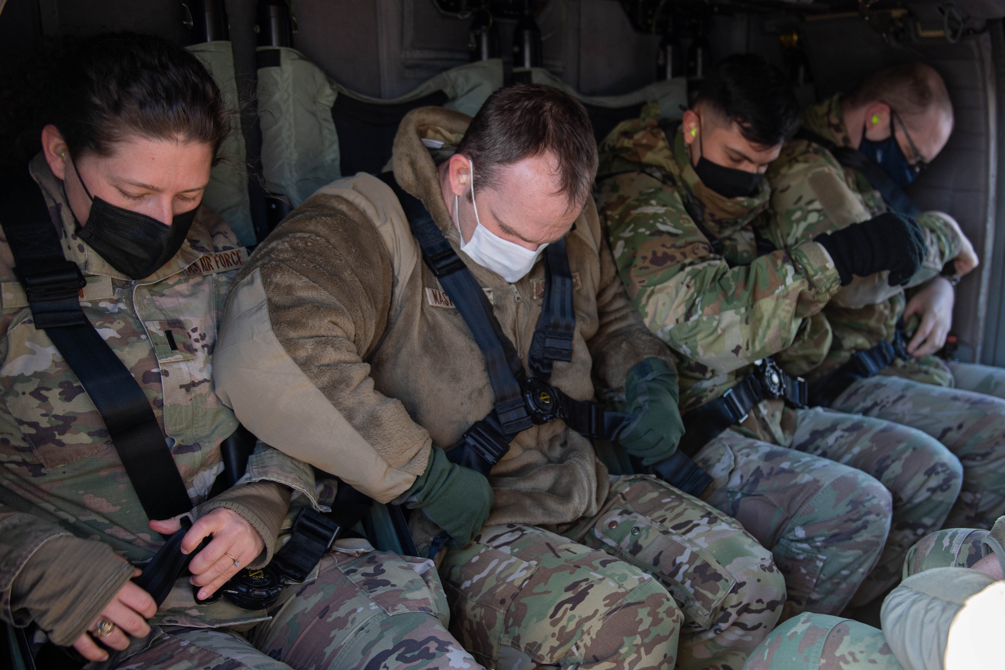 Airmen fasten belts in UH-60 Blackhawk