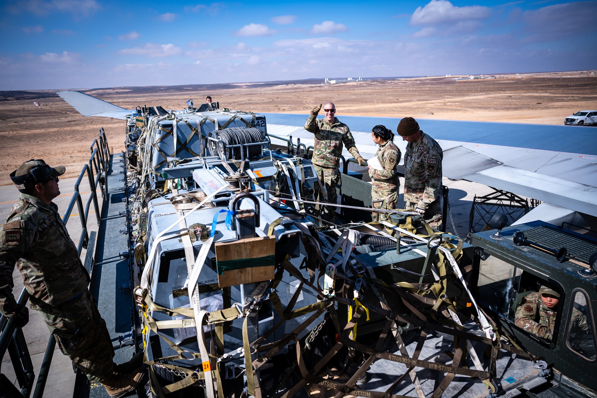 U.S. Air Force Chief Master Sgt. Sean M. Milligan, 332d Air Expeditionary Wing command chief, gives a thumbs up from on top of a K-loader during an immersion visit in Southwest Asia, Jan. 29, 2022. Chief Milligan's immersion visit give him a better understanding of the unique skillsets every Airman brings to the 332d AEW Red Tail team. (U.S. Air Force photo by Master Sgt. Christopher Parr)