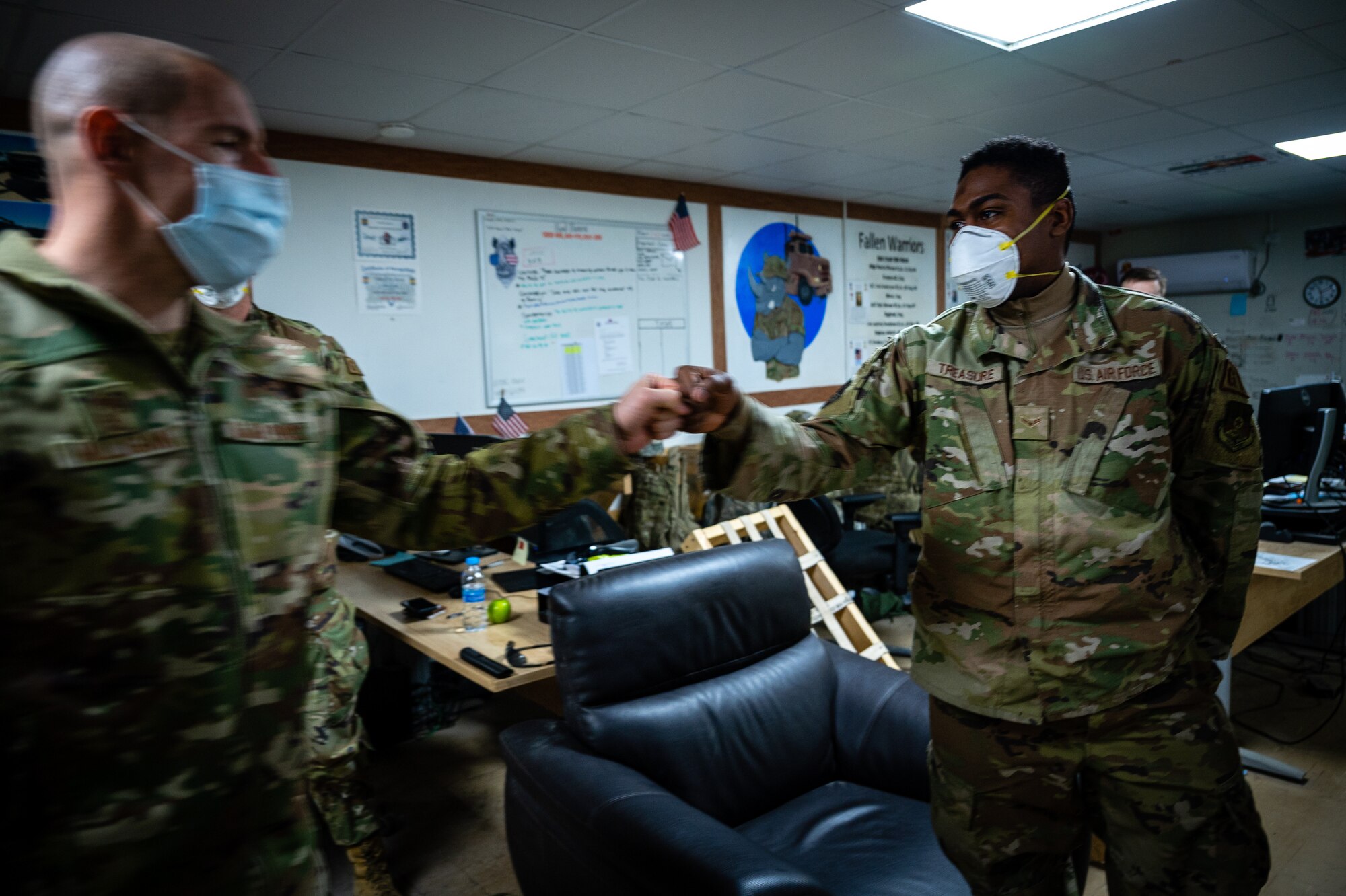 U.S. Air Force Chief Master Sgt. Sean M. Milligan, 332d Air Expeditionary Wing command chief, fist bumps Airman First Class Juvon Treasure, 332d Expeditionary Logistics Readiness Squadron vehicle operator during an immersion visit in Southwest Asia, Jan. 29, 2022. Chief Milligan's immersion visits give him a better understanding of the unique skillsets every Airman brings to the 332d AEW Red Tail team. (U.S. Air Force photo by Master Sgt. Christopher Parr)