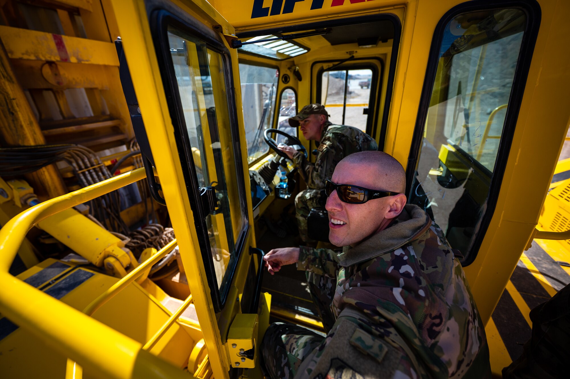 U.S. Air Force Chief Master Sgt. Sean M. Milligan, 332d Air Expeditionary Wing command chief, observes a shipping container Airman First Class James St. Aubin, 332d Expeditionary Logistics Readiness Squadron ground transportation support, moves during the Command Chief’s immersion tour in Southwest Asia, Jan. 29, 2022. The RTCH is used to move shipping containers in prep for downloading and transportation. Chief Milligan's immersion visits give him a better understanding of the unique skillsets every Airman brings to the 332d AEW Red Tail team. (U.S. Air Force photo by Master Sgt. Christopher Parr)