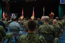 220131-A-RM286-1059 MANAMA, Bahrain (Jan. 31, 2022) Commodore Don Mackinnon, exercise vice commander, (stage left), Vice Adm. Brad Cooper, commander of U.S. Naval Forces Central Command, U.S. 5th Fleet and Combined Maritime Forces, (center stage), and Commodore Vaqar Muhmammad, exercise deputy commander, (stage right), listen to the master of ceremony during the commencement of International Maritime Exercise/Cutlass Express 2022 at Naval Support Activity Bahrain, Jan. 31. IMX/CE 2022 is the largest multinational training event in the Middle East, involving more than 60 nations and international organizations committed to enhancing partnerships and interoperability to strengthen maritime security and stability.
