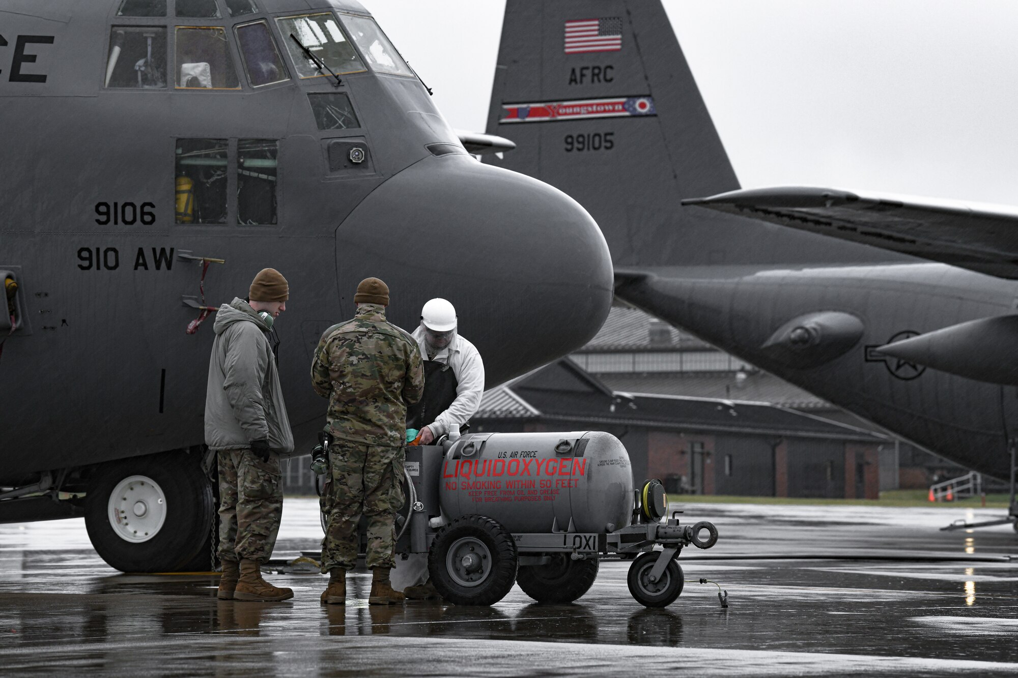 Senior Airman Lucas Crawford, Senior Airman Dylan Ryan, and Master Sgt. Robert Comstock, crew chiefs with the 910th Aircraft Maintenance Squadron, prepare to move a liquid oxygen cart on Jan. 9, 2022, on the flightline at Youngstown Air Reserve Station.