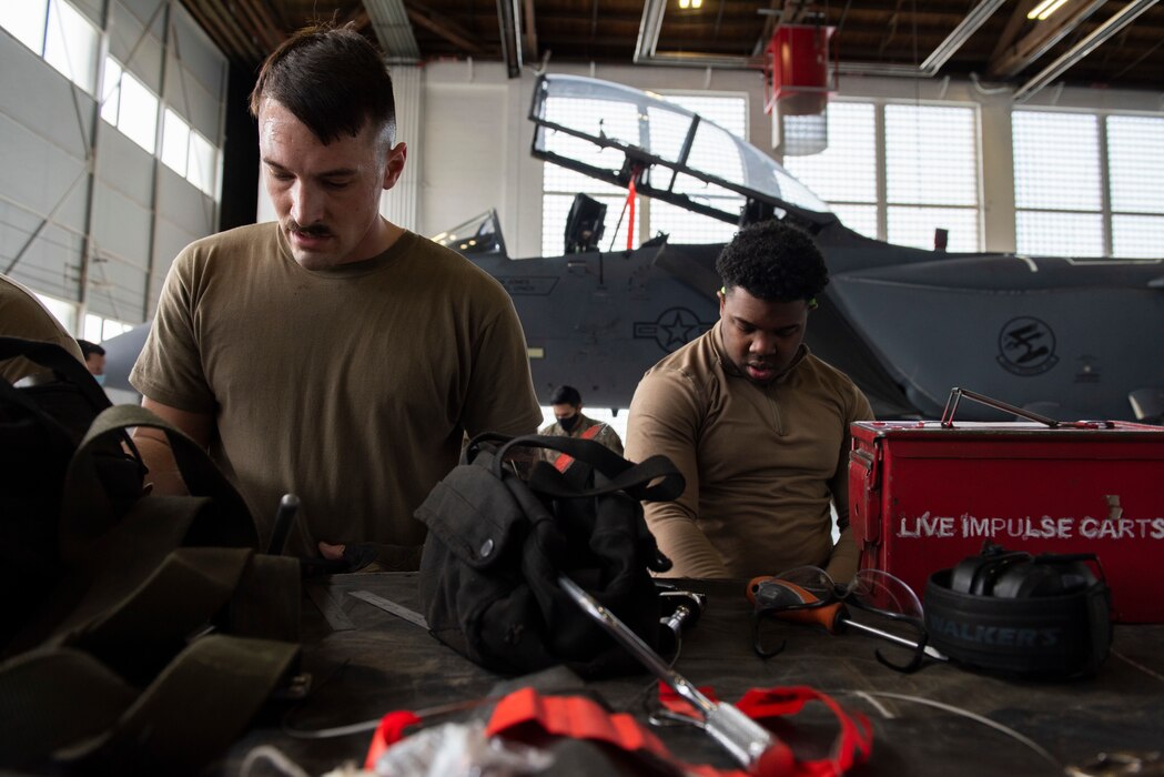 Multiple airmen put away their tools.