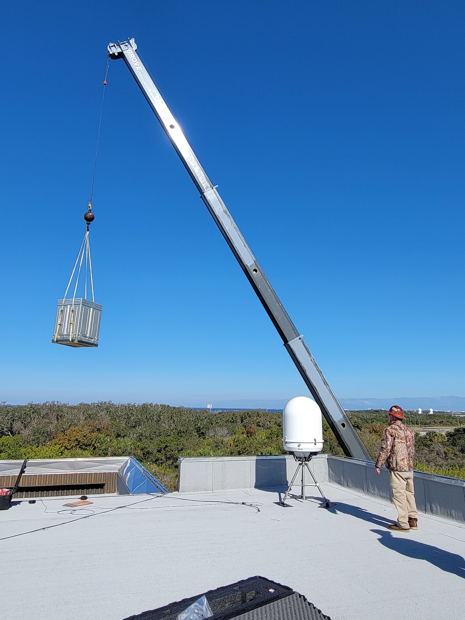 Airmen from the 2d Combat Weather Systems Squadron use a crane to place equipment required to install a Portable Doppler Radar weather system to assist Guardians with space launch operations at Cape Canaveral Space Force Station, Florida.