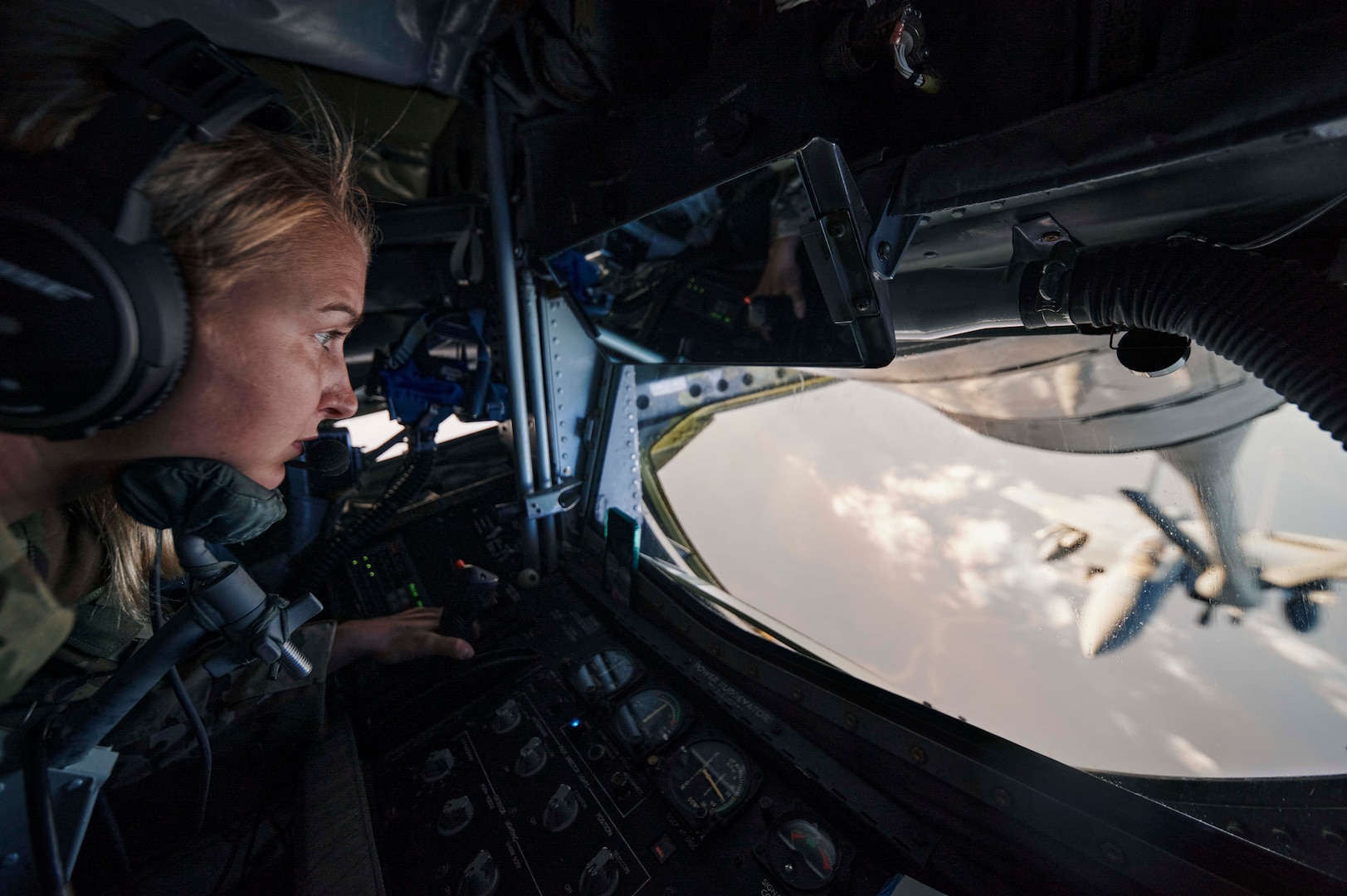 U.S. Air Force Airman 1st Class Natalia Berry, a KC-135 Stratotanker in-flight refueling specialist assigned to the 349th Expeditionary Air Refueling Squadron, prepares to refuel a U.S. Air Force F-15E Strike Eagle aircraft during a refueling mission over the U.S. Central Command area of responsibility Oct. 22, 2021.