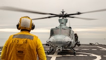 A U.S. Navy Sailor aboard the USS Wichita (LCS 13) guides a UH-1Y Venom helicopter onto a landing pad during Littoral Exercise I (LEX) on Jan. 25, 2022. During LEX I, Marines and Sailors are experimenting with new concepts and forces to prepare for future scenarios in littoral environments along the East Coast. LEX I is the first time a Blue-Green team conducted amphibious, ship-to-shore operations while embarked on a littoral combat ship. (U.S. Marine Corps photo by Cpl. Elijah J. Abernathy)