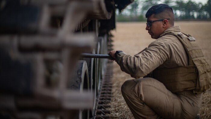 U.S. Marine Corps Lance Cpl. Matthew Ramirez, an assault amphibious amphibious vehicle crewman, and Houston, Texas native, with 2d Assault Amphibian Battalion (2d AABn), 2d Marine Division, performs maintenance during a field exercise on Camp Lejeune, North Carolina, Jan. 25, 2022. 2d AABn tested the capability of an assault amphibious vehicle and a light armored vehicle with Remote Weapon Systems as a suitable land-based platform for mobile reconnaissance and scouting. (U.S. Marine Corps photo by Lance Cpl. Ryan Ramsammy)