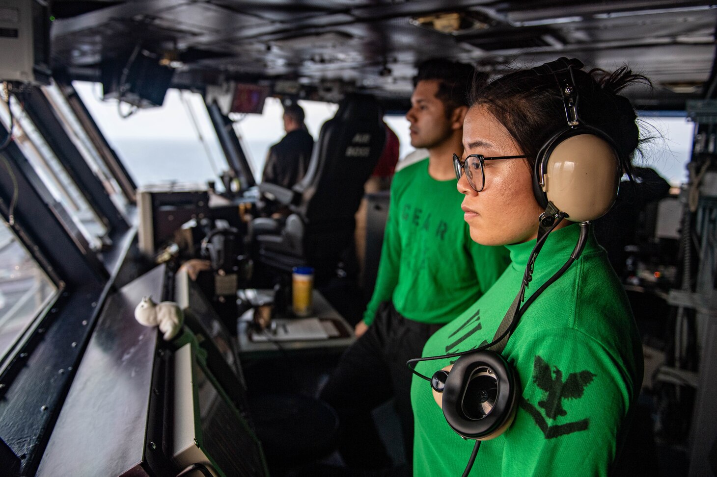 Electrician's Mate 3rd Class Chengjie Yang observes flight deck observations from primary flight control aboard the Nimitz-class aircraft carrier USS Carl Vinson (CVN 70), Jan. 25, 2022.