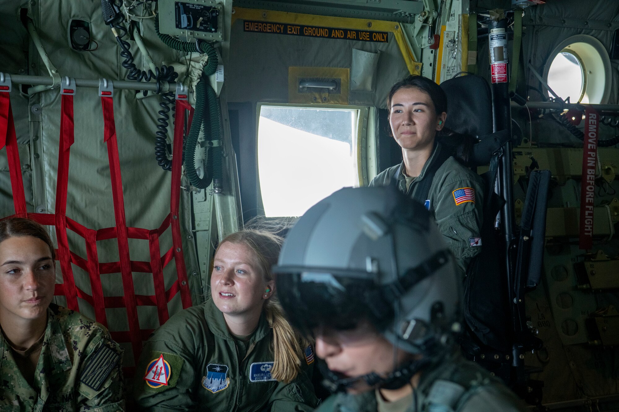 Several cadets wait in a cargo plane's cargo area.