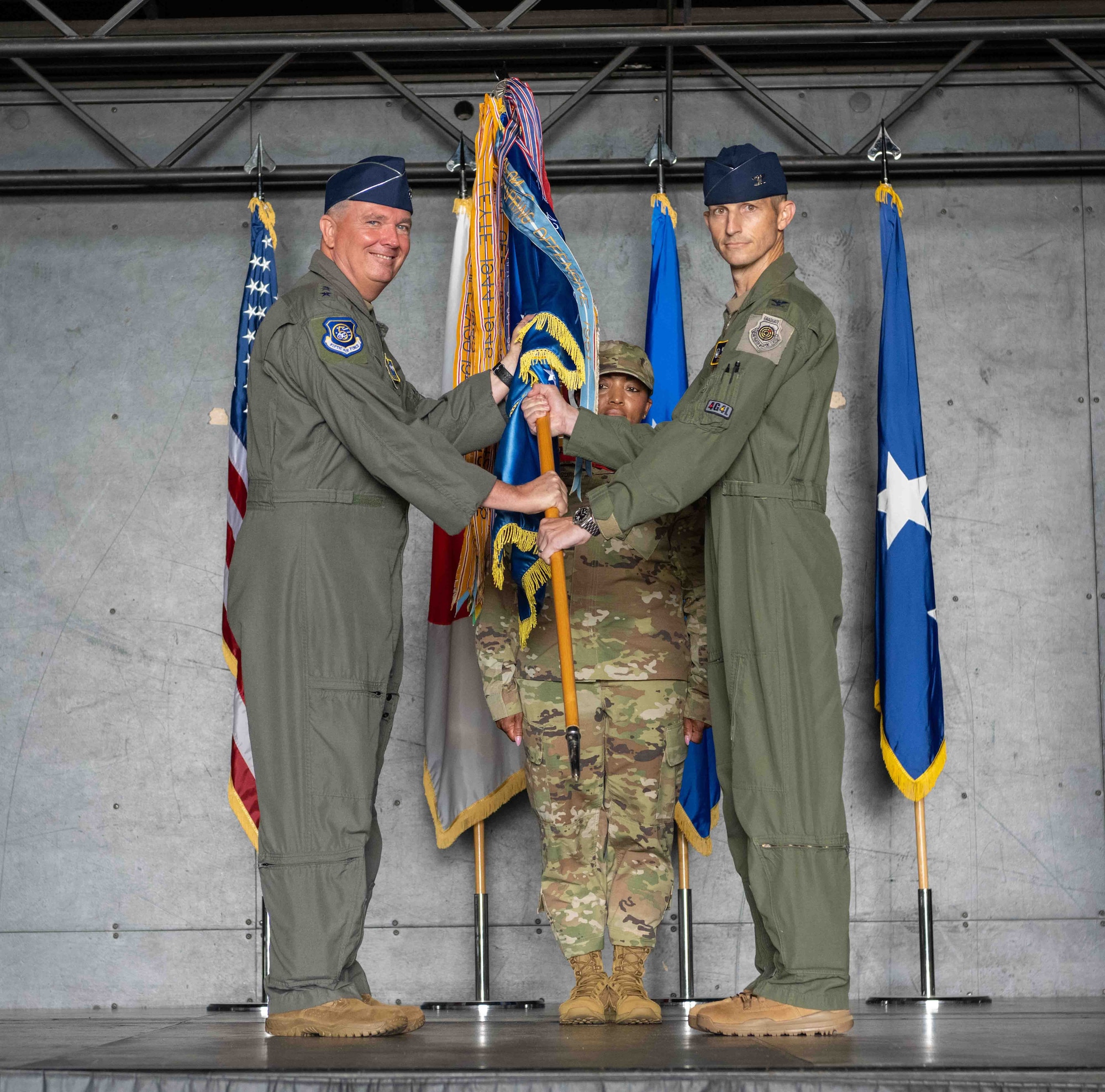 United States U.S. Air Force Lt. Gen. Ricky N. Rupp, left, U.S. Forces Japan and 5th Air Force commander, passes the guidon to Col. Michael P. Richard, right, 35th Fighter Wing (FW) incoming commander, during the 35th FW change of command ceremony at Misawa Air Base, Japan, June 30, 2022.