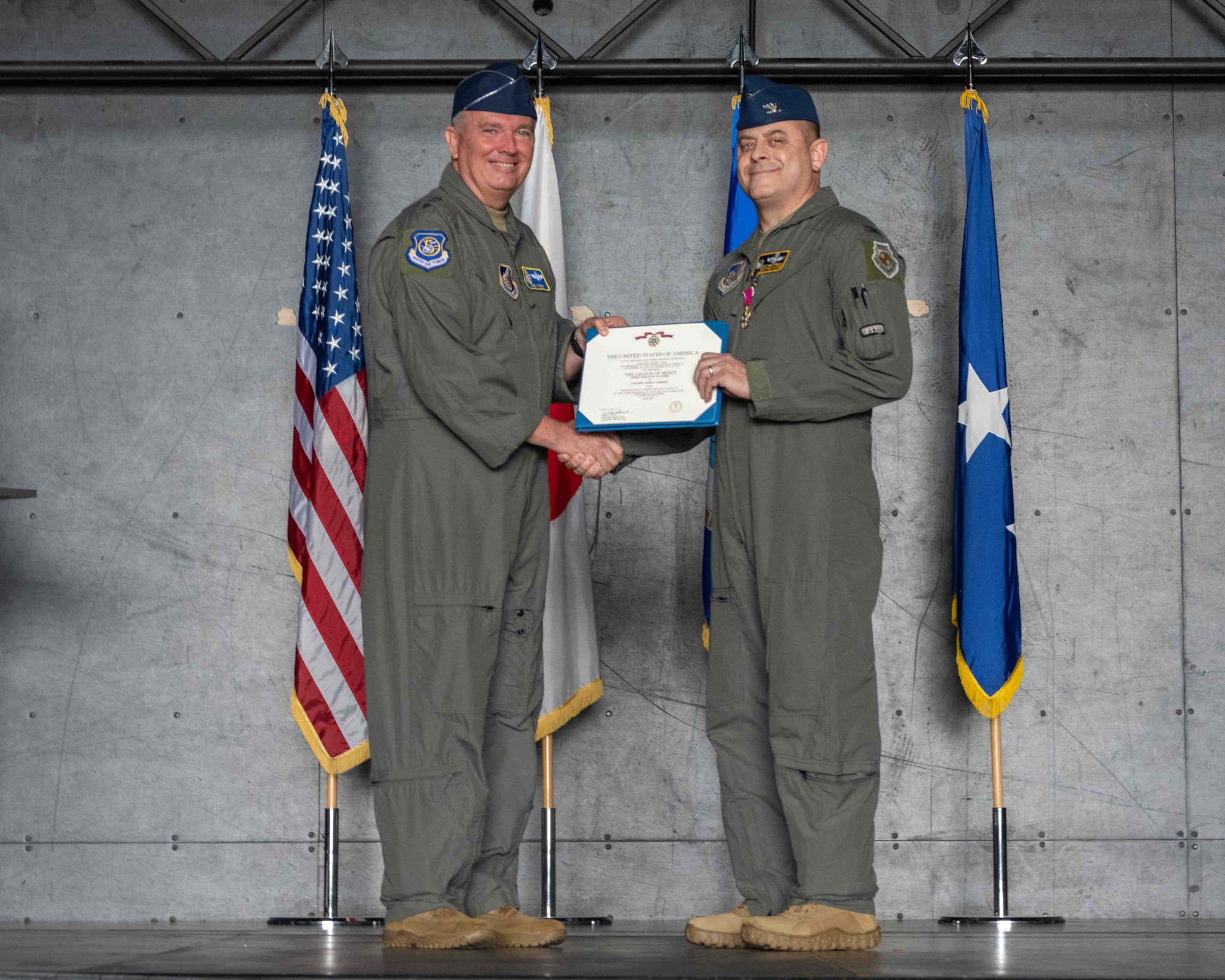United States Air Force Lt. Gen. Ricky N. Rupp, U.S. Forces Japan and 5th Air Force commander, left, presents the Legion of Merit to Col. Jesse J. Friedel, 35th Fighter Wing (FW) outgoing commander, during the 35th FW change of command ceremony at Misawa Air Base, Japan, June 30, 2022.