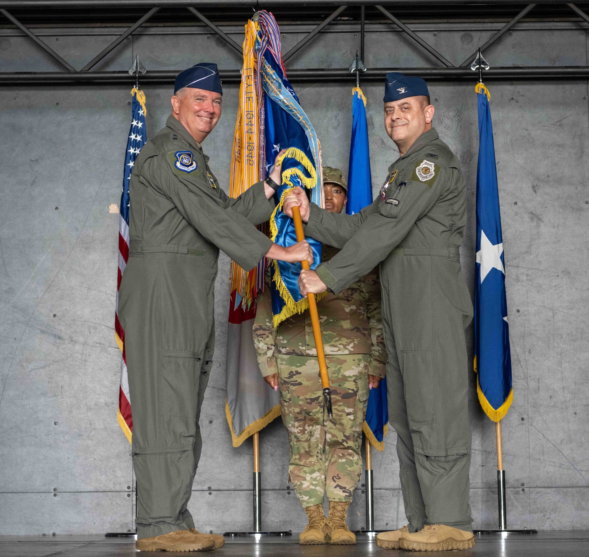 United States Air Force Col. Jesse J. Friedel, right, 35th Fighter Wing (FW) outgoing commander, passes a guidon to Lt. Gen. Ricky N. Rupp, left, U.S. Forces Japan and 5th Air Force commander, during the 35th FW change of command ceremony at Misawa Air Base, Japan, June 30, 2022.