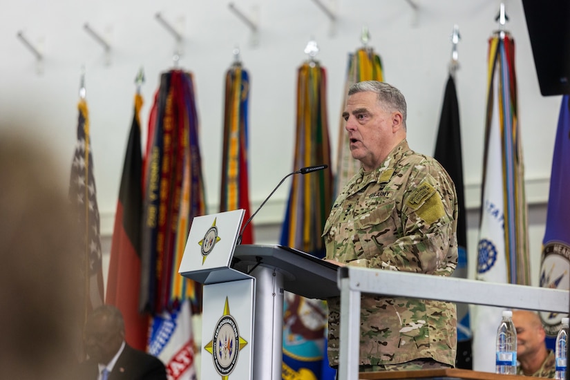 A man in uniform speaks from behind a podium.