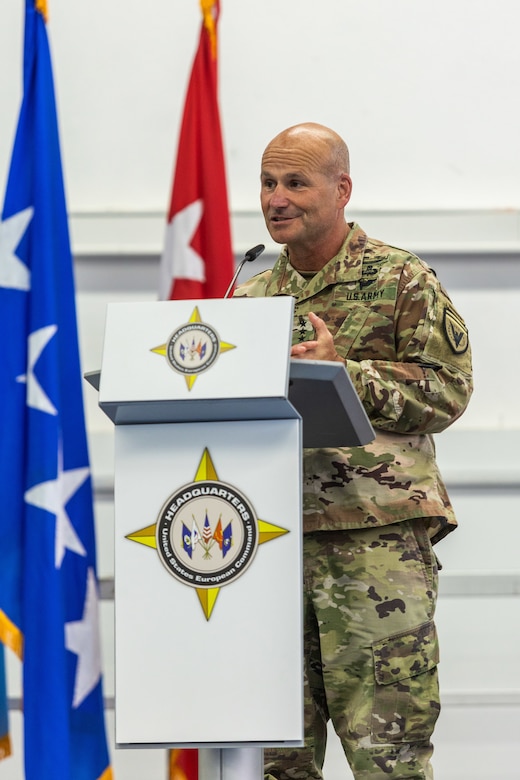 A man dressed in a military uniform stands at a podium.