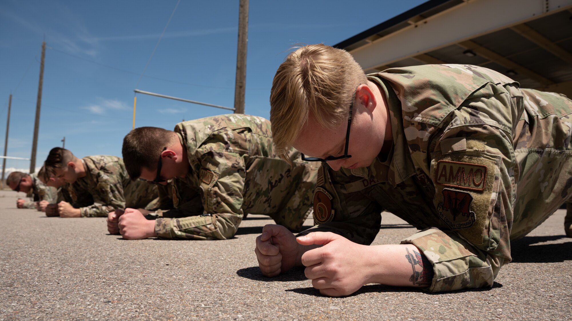 Senior Airman Katelyn Day, 388th Munitions Squadron, along with other Airman hold a plank pose during a timed assessment at Hill Air Force Base, Utah,