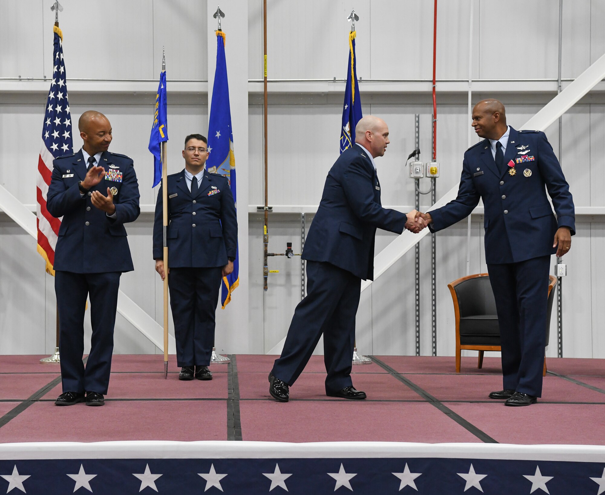 Col. Jason Vap, center, commander of the 804th Test Group, Arnold Engineering Development Complex, shakes hands with Col. Linc Bonner, the previous 804 TG commander, during a change of command ceremony June 21, 2022, in the Aircraft Test Support Facility at Arnold Air Force Base, Tennessee. Also pictured are Col. Randel Gordon, left, AEDC commander, and Capt. Christopher Fernandez, guidon bearer. (U.S. Air Force photo by Jill Pickett)