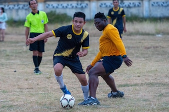 Religious Program Specialist Adeyemi Oluwadamilola, right, plays against the Vietnamese Tuyan District soccer team during a Pacific Partnership 2022 (PP22) host nation outreach event at the Tuy An district sport center.
