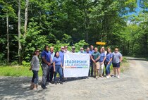 Photo of Lauren Tomaino and Robert McLaughlin posing with their team and Leadership Lackawanna board members at Camp Freedom.