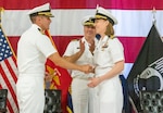 IMAGE: Outgoing Naval Surface Warfare Center Dahlgren Division Dam Neck Activity Commanding Officer Cmdr. Matthew Erdner shakes hands with incoming Commanding Officer Cmdr. Christina Carino at the end of the change of command ceremony June 29, at Naval Air Station Oceana in Virginia Beach.