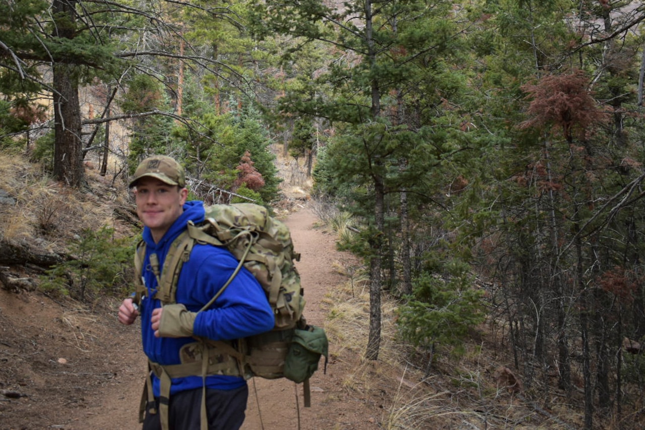 A person hikes with a backpack in the forest.