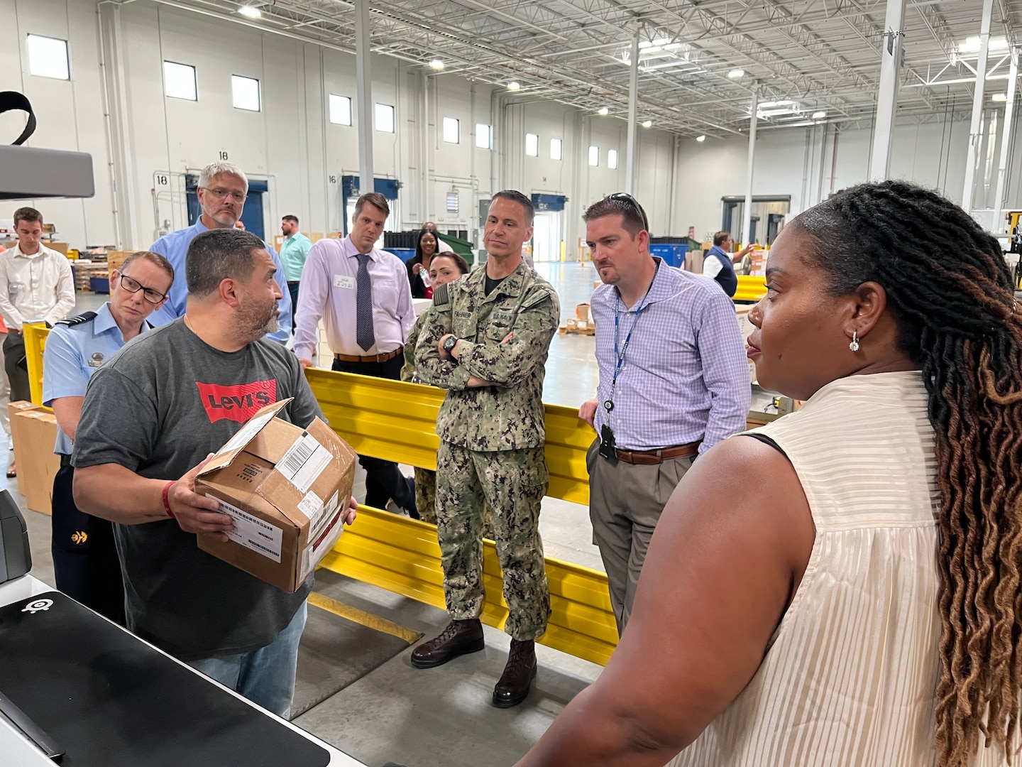 People gathered around a man holding a box ready for shipping.