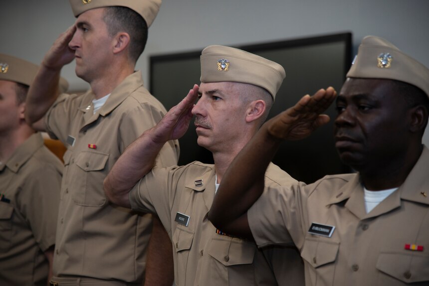 Chaplains at Naval Chaplaincy School (NCS) salute while the national anthem plays during the NCS assumption of command ceremony at Naval Station Newport, June 30, 2022.