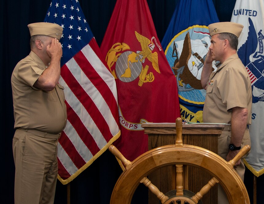 Capt. Charles Varsogea, right, reports to Capt. Robert Stockton, commanding officer, Center for Service Support, as Varsogea assumes command of the Naval Chaplaincy School (NCS) during a ceremony at Naval Station Newport, June 30, 2022.