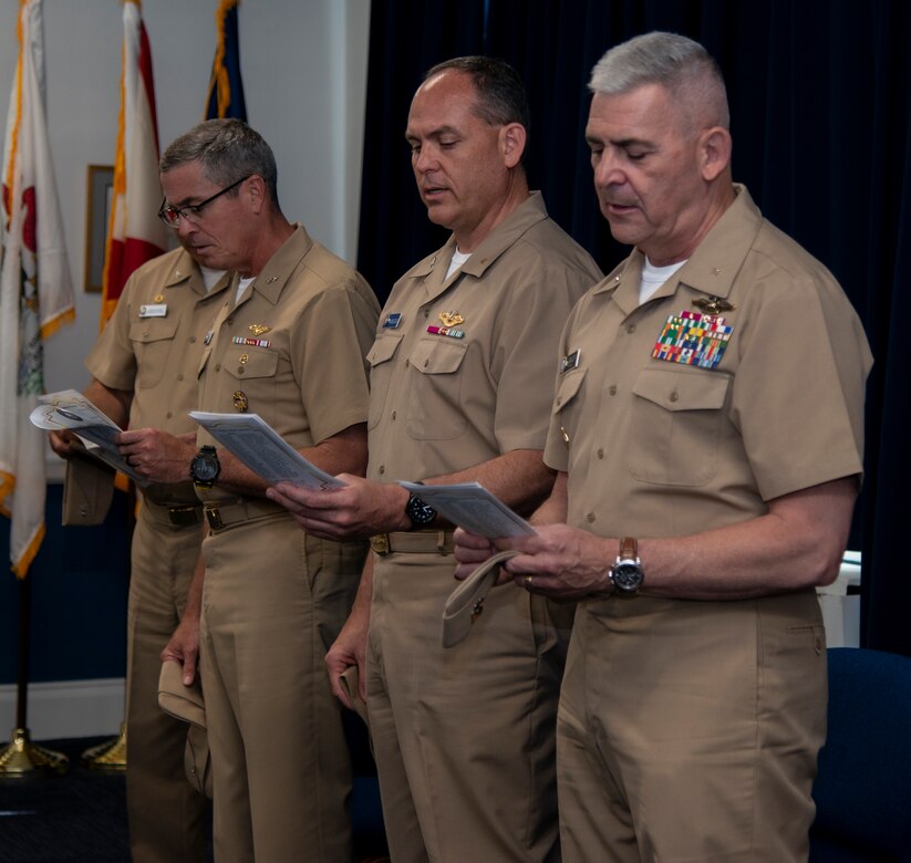 From left, Rear Adm. Pete Garvin, commander, Naval Education and Training Command, Capt. Charles Varsogea, commanding officer, Naval Chaplaincy School (NCS), and Chief of Chaplains of the Navy Rear Adm. Gregory Todd sing “Eternal Father, Strong to Save” during the NCS assumption of command ceremony at Naval Station Newport, June 30, 2022.