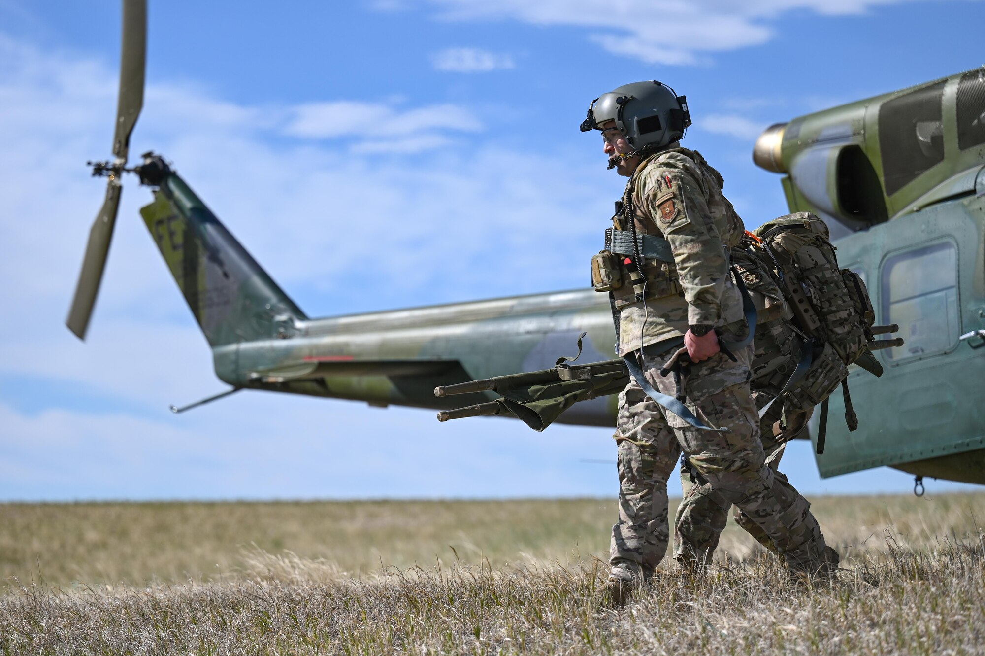 Aircrew of the 37th Helicopter Squadron depart a UH-1N Huey to bring injured to Cheyenne Regional Medical Center during the 2022 major accident response exercise, June 29, 2022, on F.E. Warren Air Force Base, Wyoming. Medical evacuation and transport is one of the several primary mission sets of the helicopter. (U.S. Air Force photo by Landon Gunsauls)