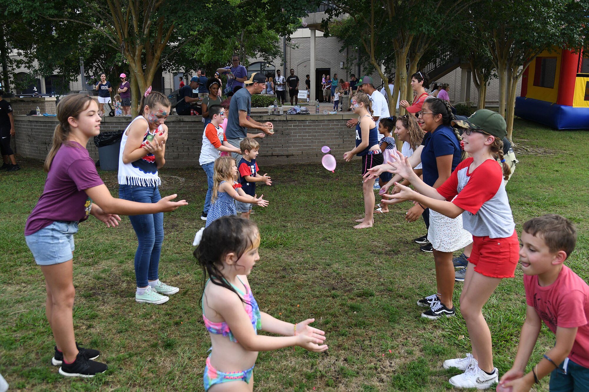 Keesler personnel and families participate in a water balloon toss competition during Freedom Fest at the Bay Breeze Event Center on Keesler Air Force Base, Mississippi, June 30, 2022. The event also included hot wings and watermelon eating contests and fireworks. (U.S. Air Force photo by Kemberly Groue)