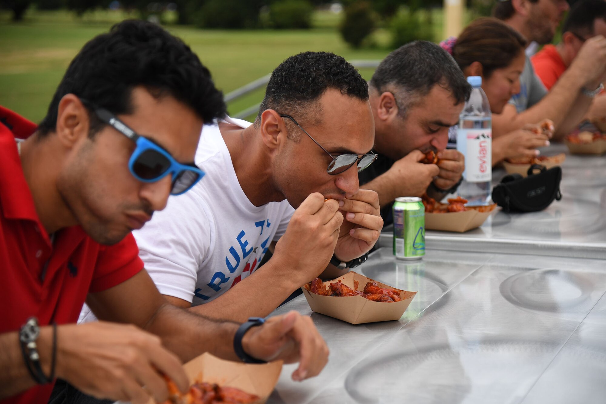 Keesler personnel participates in a hot wings eating contest during Freedom Fest at the Bay Breeze Event Center on Keesler Air Force Base, Mississippi, June 30, 2022. The event also included a watermelon eating contest, a frozen mullet toss competition and fireworks. (U.S. Air Force photo by Kemberly Groue)