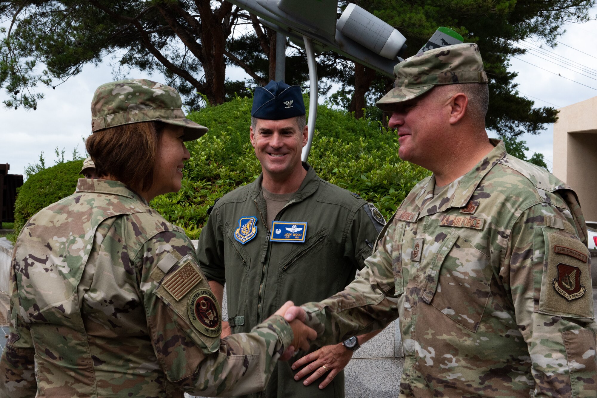 Chief Master Sgt. of the Air Force JoAnne S. Bass, left, greets Col. Joshua Wood, center, 51st Fighter Wing commander, and Chief Master Sgt. Justin Apticar, 51st FW command chief, upon arriving at Osan Air Base, Republic of Korea, June 28, 2022.