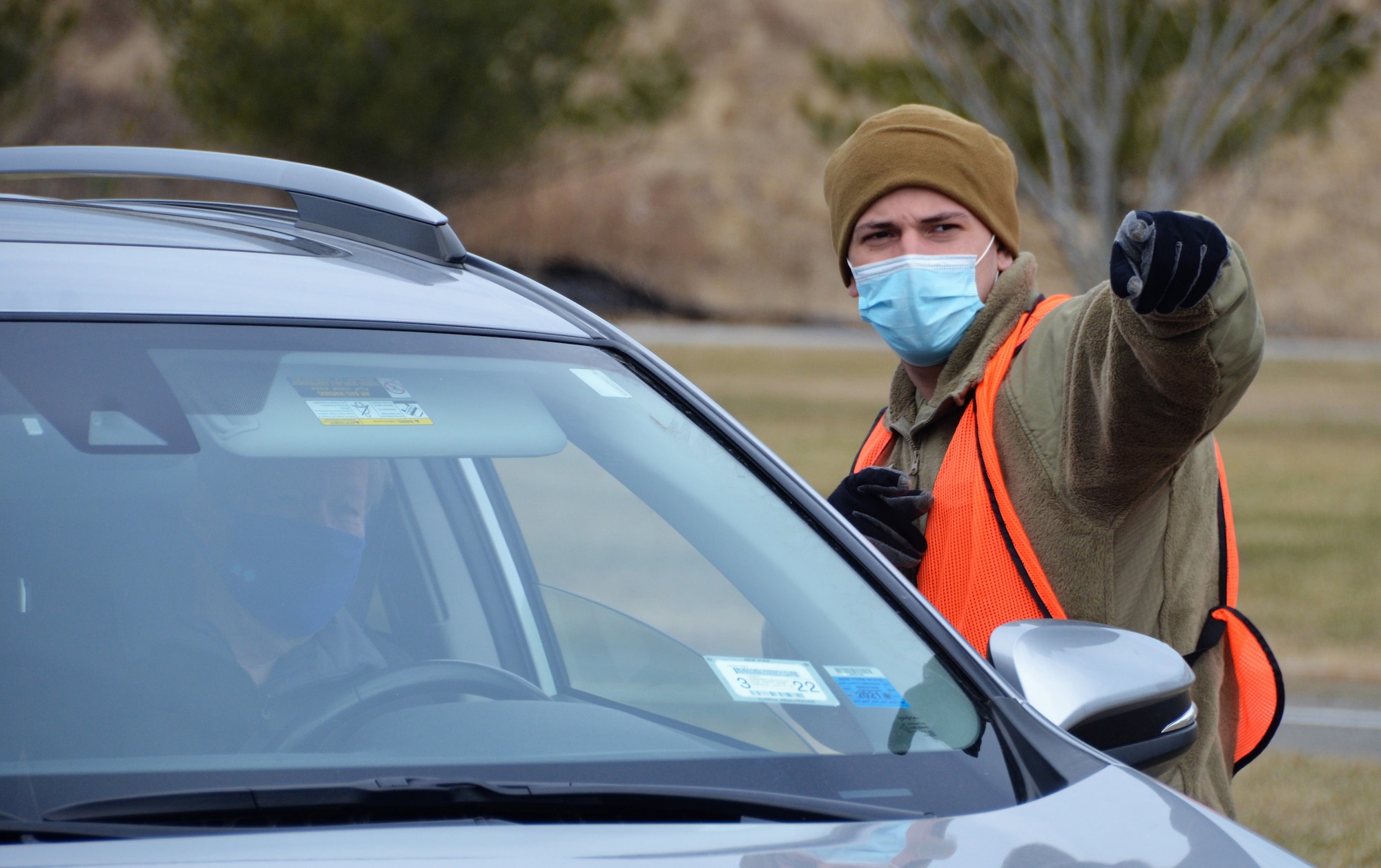 New York Army National Guard Pvt. Joshua Morales, a member of the 133rd Combat Support Company, directs a COVID-19 vaccination registrant to The State University of New York, Stony Brook, vaccination site March 16th, 2021.