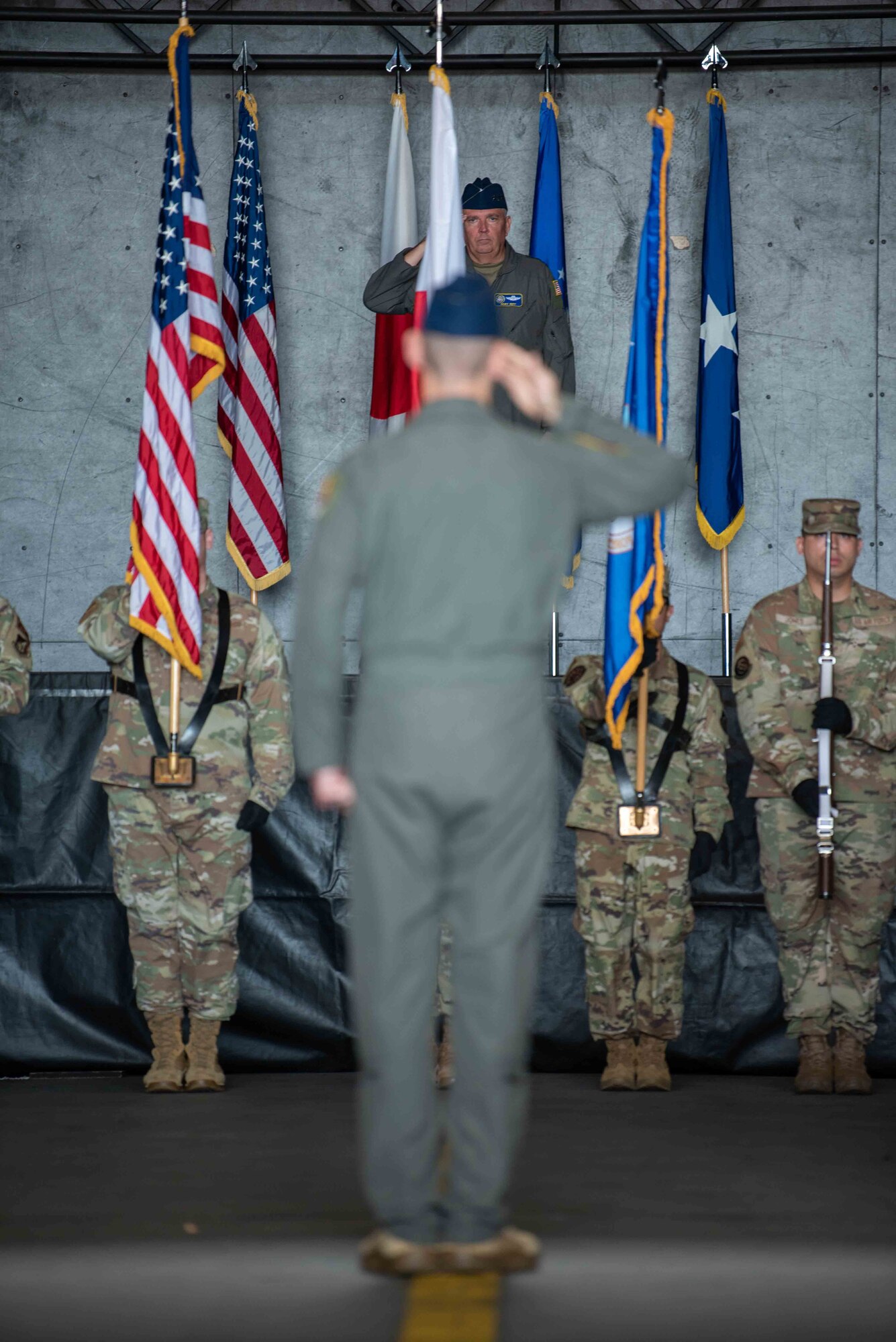 Members of the 35th Fighter Wing (FW) render a salute for the playing of the national anthem during the 35th FW change of command ceremony at Misawa Air Base, Japan, June 30, 2022.