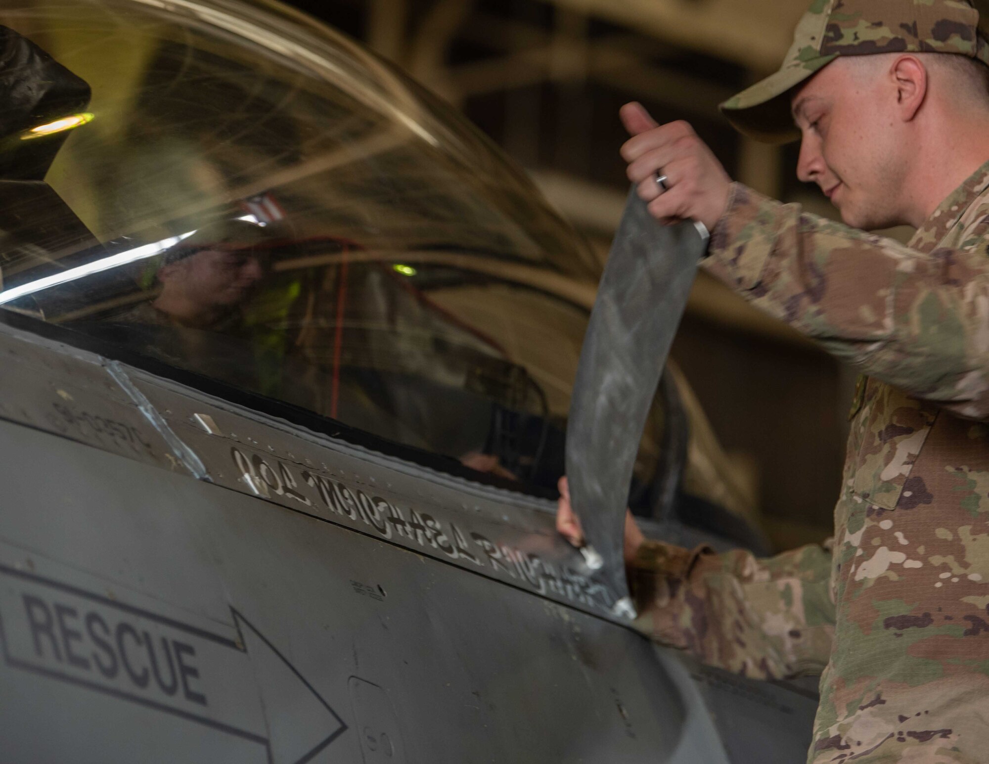 United States Air Force Staff Sgt. Ryan Gurrieri, 35th Aircraft Maintenance Squadron dedicated crew chief, unveils a nametape for Col. Michael P. Richard, 35th Fighter Wing (FW) commander, on his F-16 Fighting Falcon during the 35th FW change of command ceremony at Misawa Air Base, Japan, June 30, 2022.