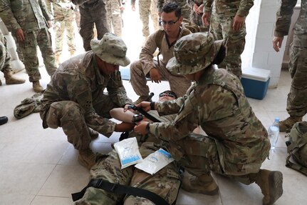 U.S. Marine Petty Officer 3rd Class Armando Quezada, a hospital corpsman with the Fleet Marine Force, 22nd Marine Expeditionary Unit, and U.S. Army Reserve members of the 349th Field Hospital, demonstrate stabilizing body temperature for a heat casualty patient and preparing them for transport at a Tunisian Armed Forces base in Bizerte, Tunisia, as part of African Lion 22, June 22, 2022. African Lion 2022 is U.S. Africa Command's largest, premier, joint, annual exercise hosted by Morocco, Ghana, Senegal and Tunisia, June 6 - 30. More than 7,500 participants from 28 nations and NATO train together with a focus on enhancing readiness for U.S. and partner nation forces. AL22 is a joint all-domain, multi-component, and multinational exercise, employing a full array of mission capabilities with the goal of strengthening interoperability among participants and setting the theater for strategic access. (U.S. Army photo by Cdt. Esperanza Deterding, 105th Mobile Public Affairs Detachment)