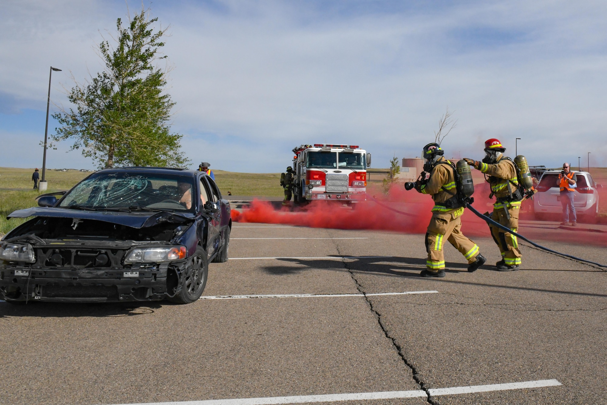 90th Civil Engineer Squadron firefighters respond to a damaged vehicle during the 2022 major accident response exercise, June 29, 2022, on F.E. Warren Air Force Base, Wyoming. Firefighters rushed-in to transport injured to be triaged by medical providers. (U.S. Air Force photo by Landon Gunsauls)