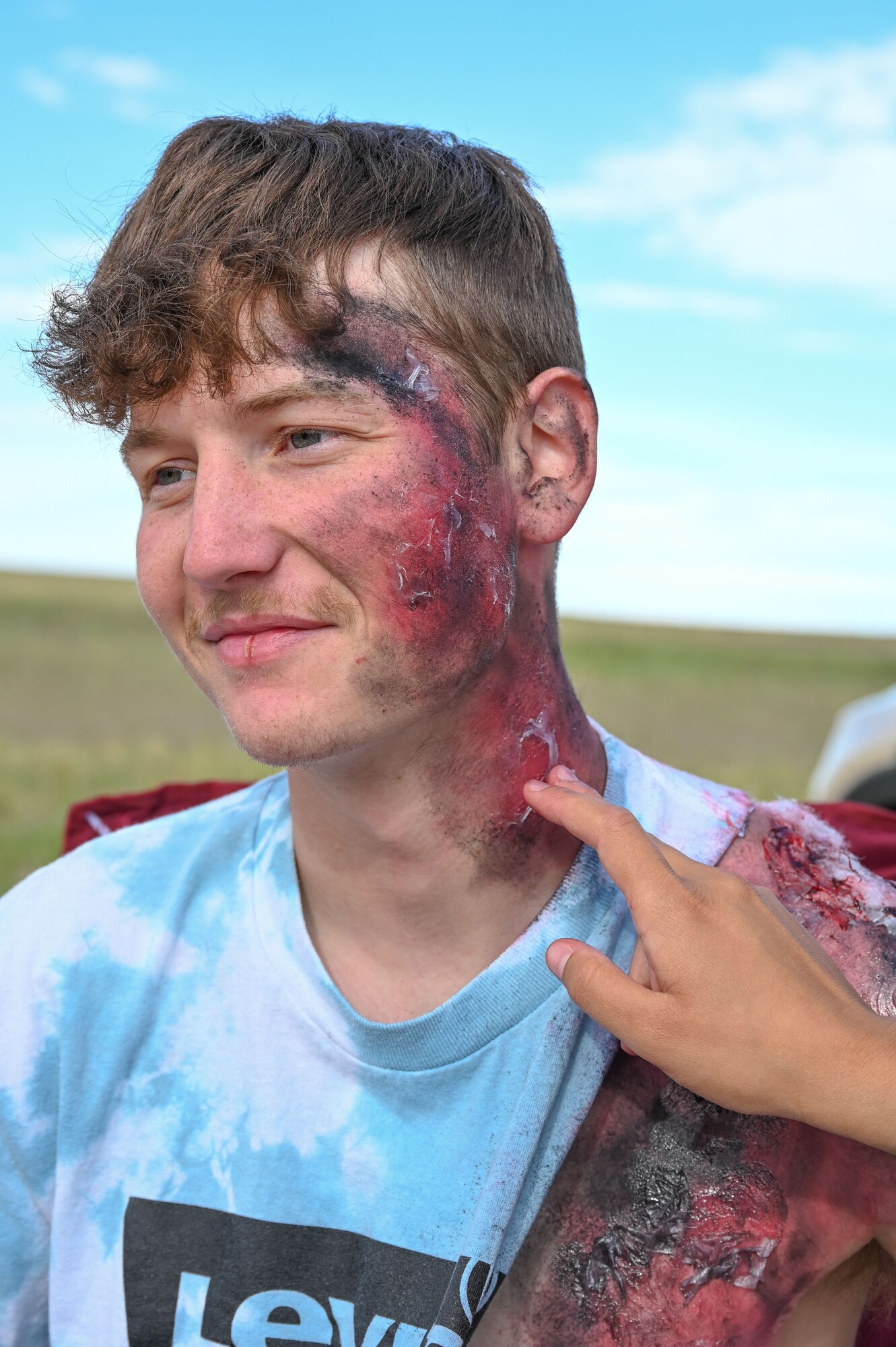 Airman Riley Ervin, 790th Missile Security Forces Squadron member, has moulage applied to him for the 2022 major accident response exercise, June 29, 2022, on F.E. Warren Air Force Base, Wyoming. Exercises serve to prepare 90th Missile Wing members for real-world events. (U.S. Air Force photo by Airman 1st Class Sarah Post)