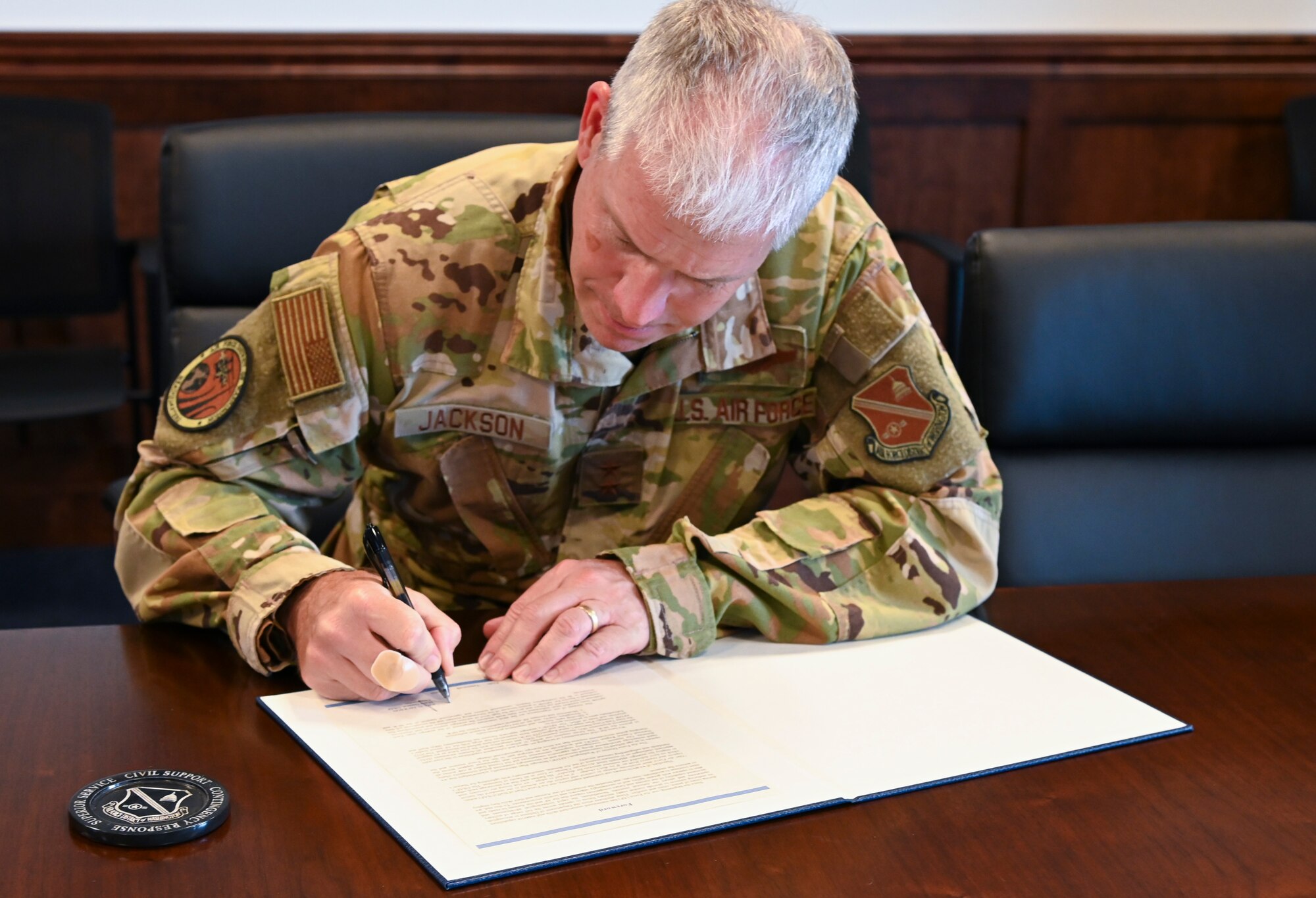 Man in uniform signs paper