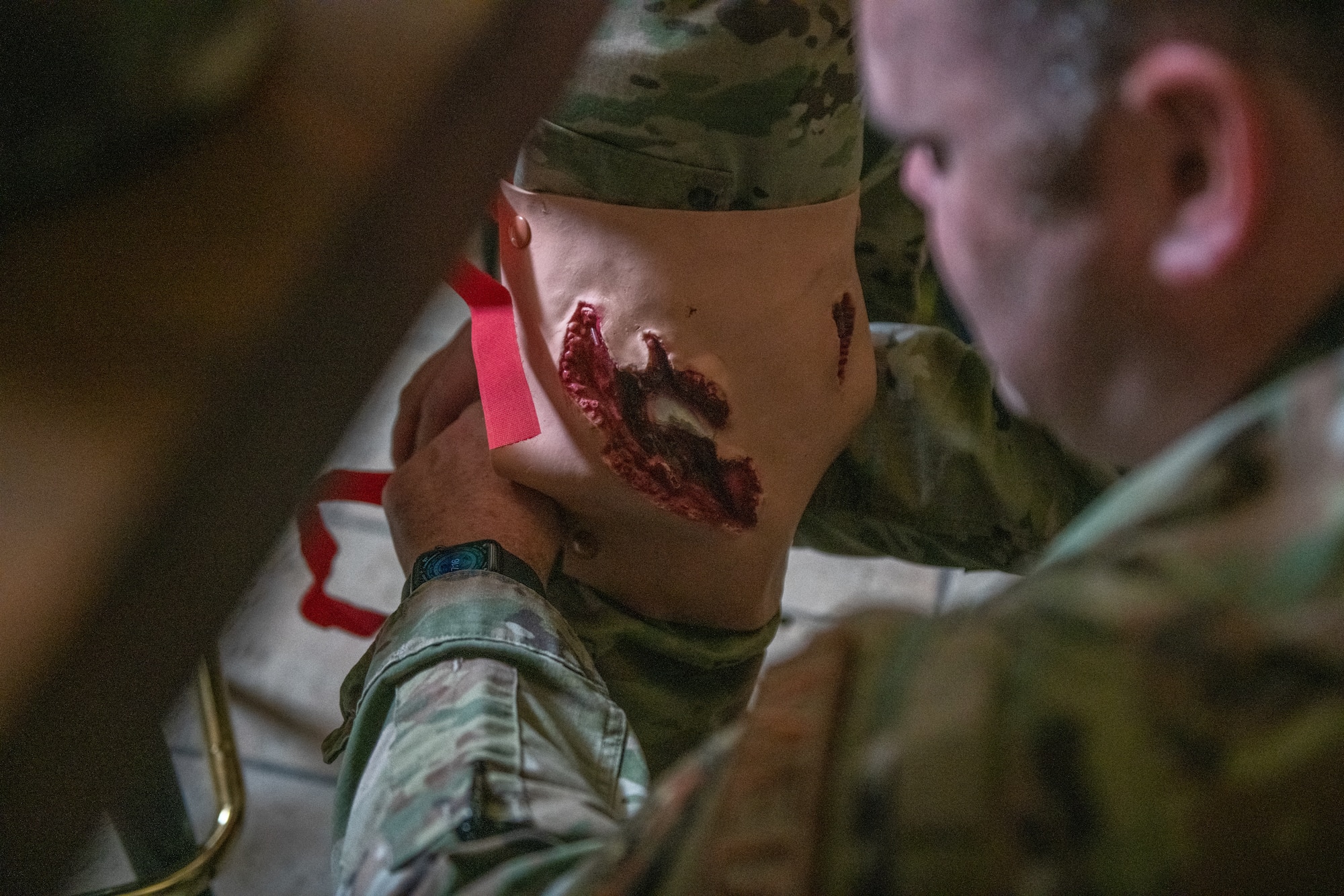 U.S. Air Force Master Sgt. Jeremiah Sutton, a medical specialist with the 379th Expeditionary Operational Medical Readiness Squadron, applies a fake wound to an exercise participant on Al Udeid Air Base, Qatar, June 27, 2022. Fake wounds are placed on simulated casualties in order to help first responders triage and treat casualties appropriately. (U.S. Air National Guard photo by Airman 1st Class Constantine Bambakidis)