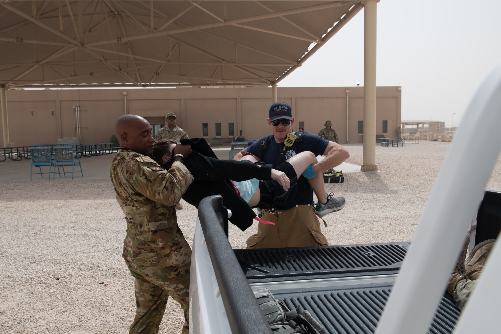 U.S. Air Force firefighters with the 379th Expeditionary Civil Engineering Squadron load a simulated casualty into the back of a pickup truck during an exercise on Al Udeid Air Base, Qatar, June 27, 2022. First responders provide the quickest and most effective care that the scenario will allow. (U.S. Air National Guard photo by Airman 1st Class Constantine Bambakidis)