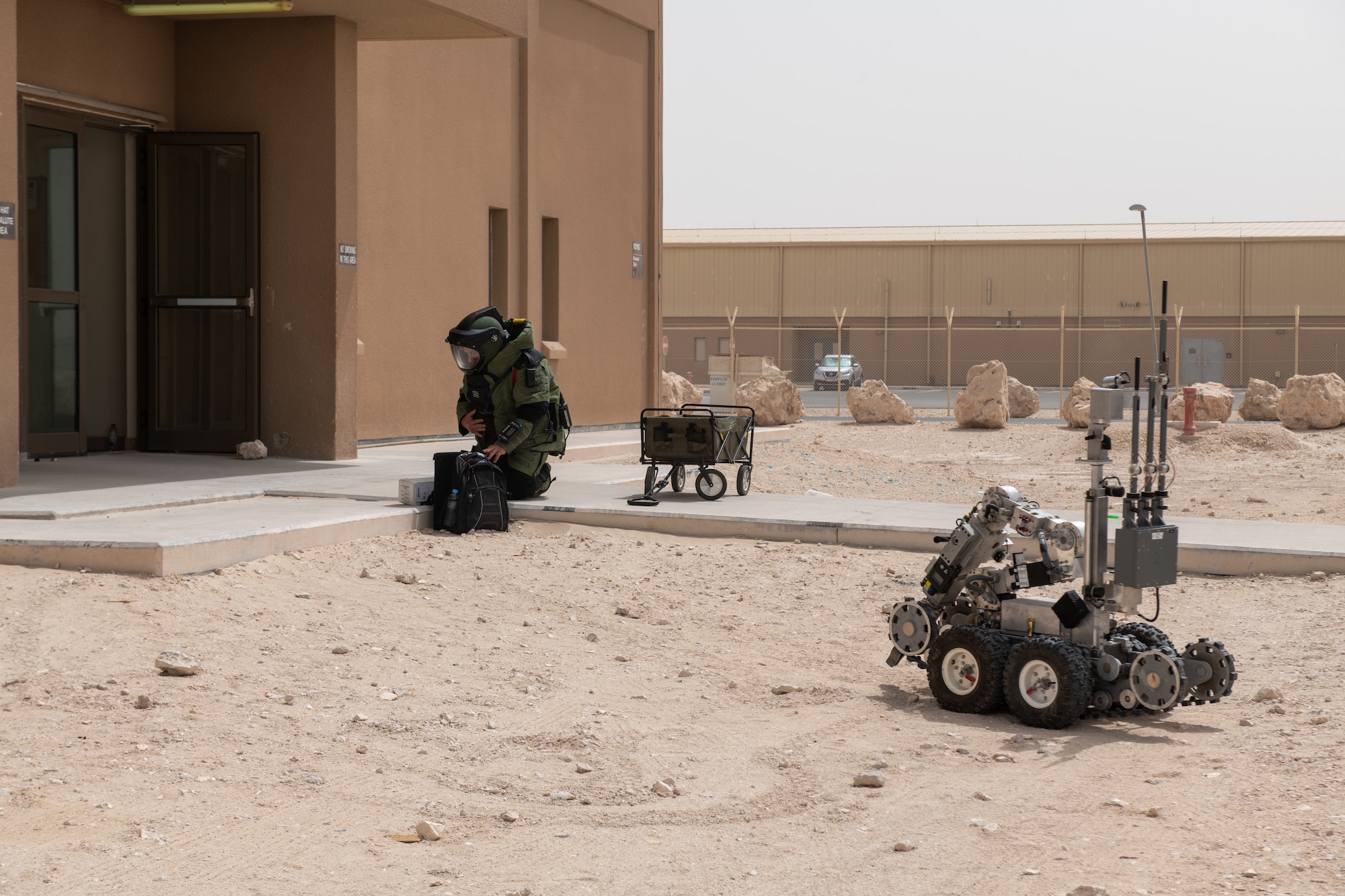 U.S. Air Force Staff Sgt. George Cochran, an explosive ordinance disposal specialist with the 379th Expeditionary Civil Engineering Squadron, communicates with his team during an exercise on Al Udeid Air Base, Qatar, June 27, 2022. Robots can assist EODs when disposing of ordinance. (U.S. Air National Guard photo by Airman 1st Class Constantine Bambakidis)