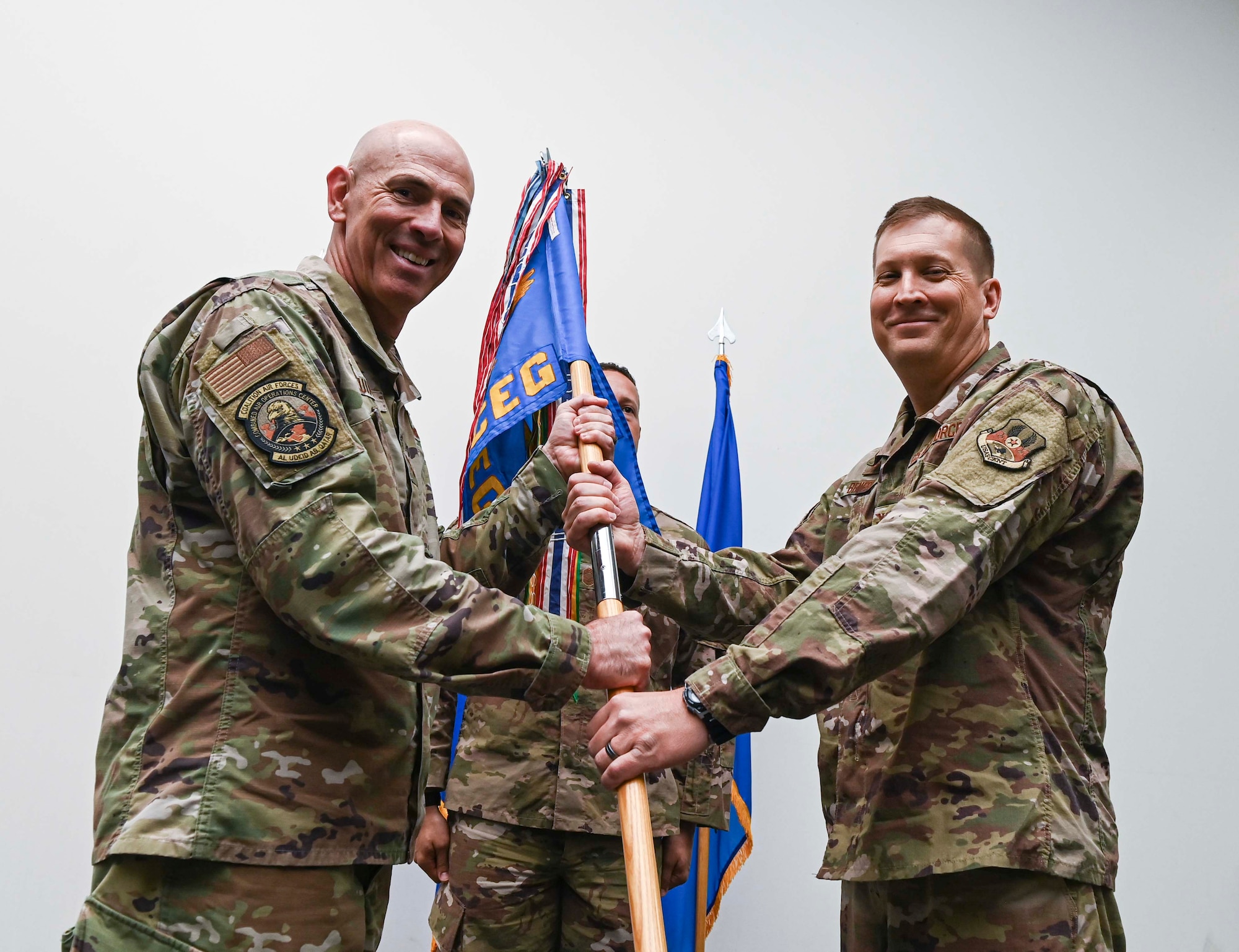 U.S. Air Force Maj. Gen. Clark J. Quinn, left, Assistant Deputy Commander, Ninth Air Force (Air Forces Central), presents a unit flag to Col. Matthew H. Beverly, right, as he assumes command of the 1st Expeditionary Civil Engineer Group, during the 1st ECEG change of command ceremony at Al Udeid Air Base, Qatar June 21, 2022.