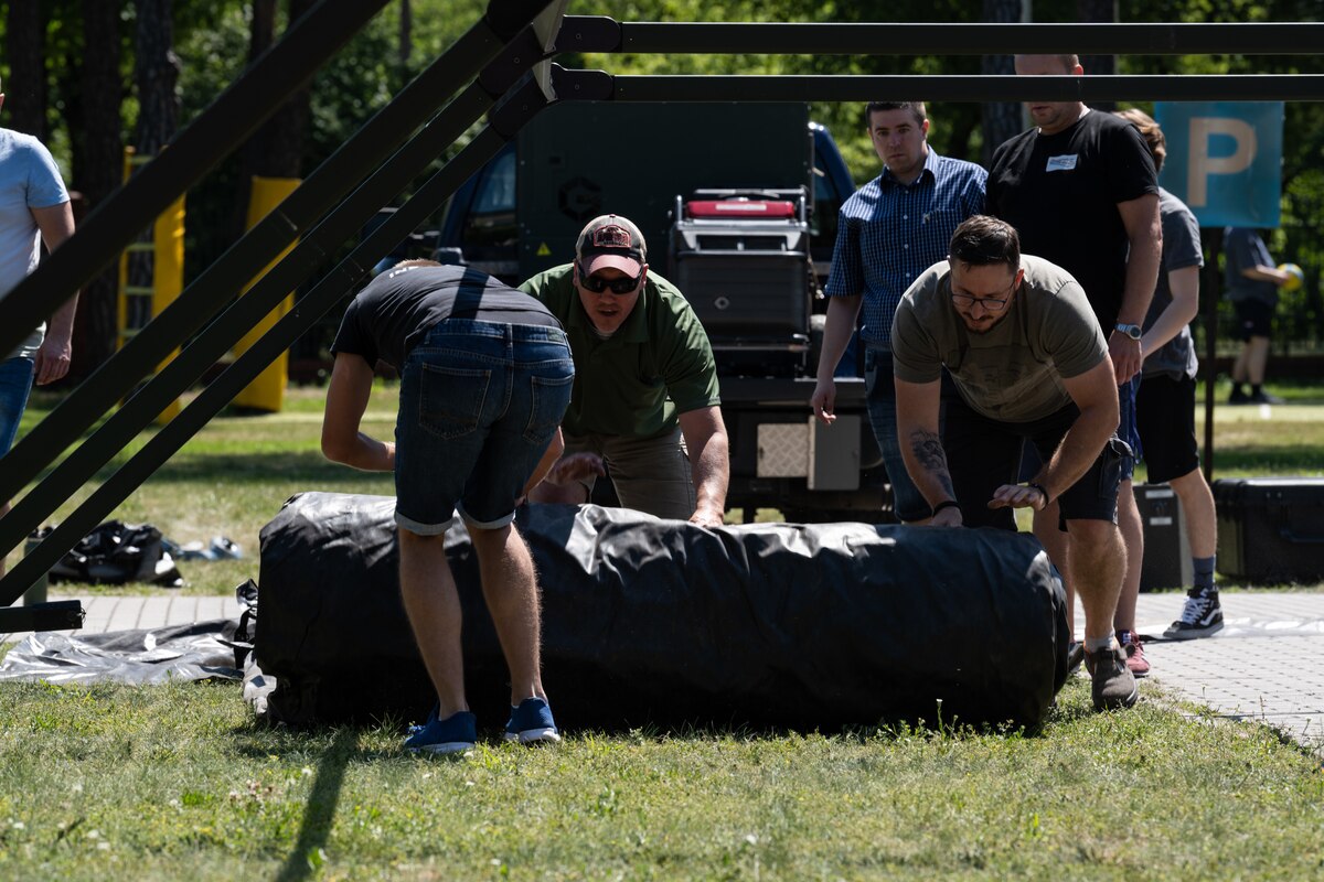 People construct field tent.