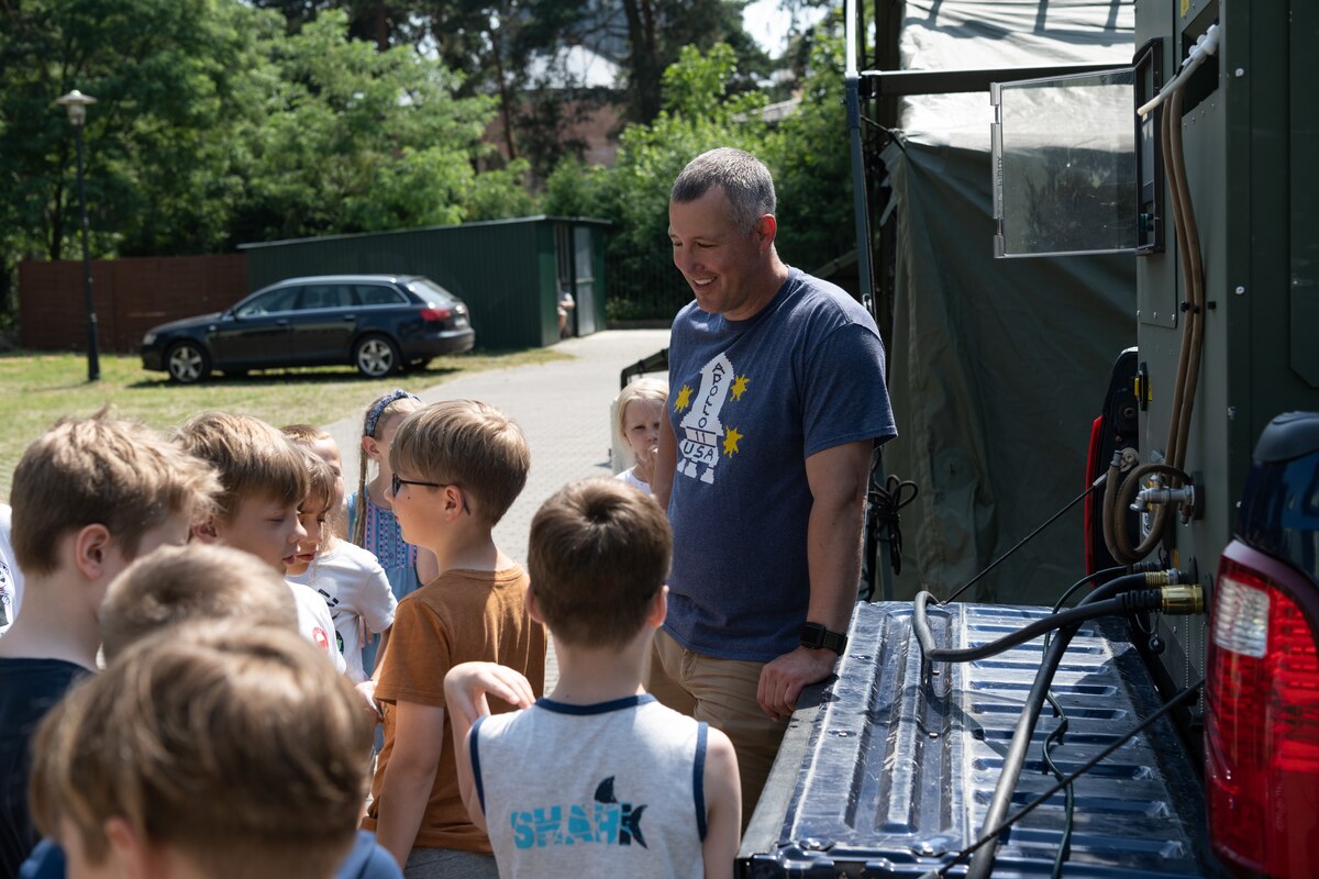 Airman gives a demonstration of Project ArcWater to children at a summer camp.
