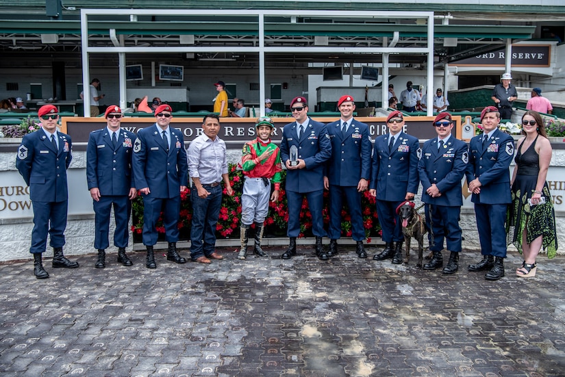Eight Airmen from the Kentucky Air National Guard’s 123rd Special Tactics Squadron present a trophy following a thoroughbred horse race at Churchill Downs in Louisville, Ky., June 12, 2022, honoring Tech. Sgt. Travis Brown, a pararescueman from the 123rd STS who died Feb. 16. More than 150 Airmen, friends and family members attended the event to pay their respects. (U.S. Air National Guard photo by Tech. Sgt. Joshua Horton)