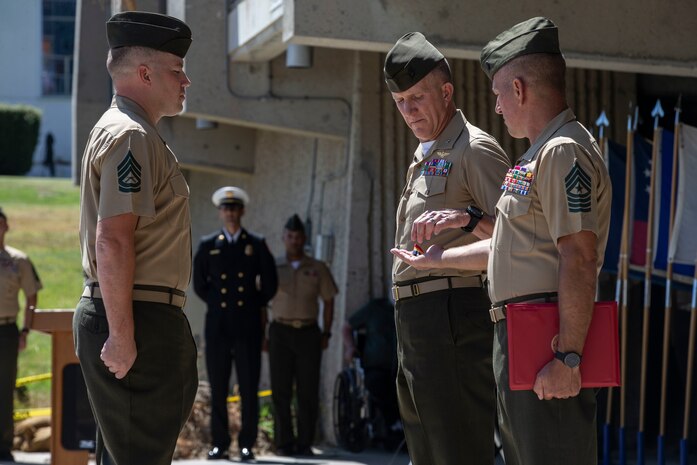 U.S. Marine Gunnery Sgt. Kyle Wetter, the staff noncommissioned officer in charge for the marksmanship training division with Headquarters and Support Battalion, Marine Corps Installations West, Marine Corps Base Camp Pendleton, waits to receive a Navy and Marine Corps Medal from Brig. Gen. Jason Woodworth and Sgt. Maj. Matthew Hackett, the commanding general and sergeant major of MCI-West, MCB Camp Pendleton, during an award ceremony on Camp Pendleton, Calif., June 30, 2022. Wetter was awarded for the heroism he displayed in December 2020 to save a family when he saw a car burst into flames on the side of a road during his drive home. Wetter climbed into the backseat of the burning car and used a pocket knife to free a child from her car seat.